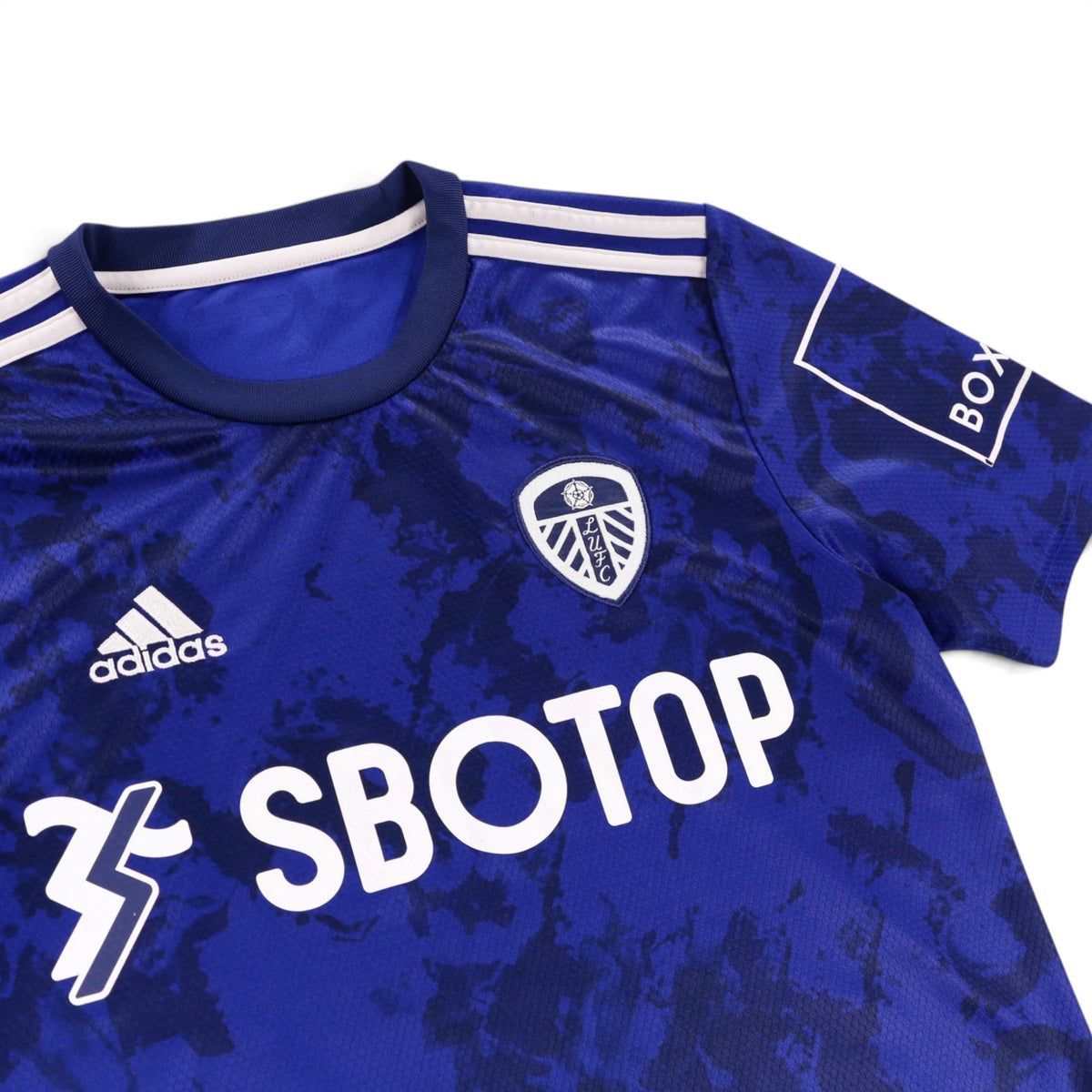 Close-up of Leeds United crest, adidas logo and collar on the away shirt