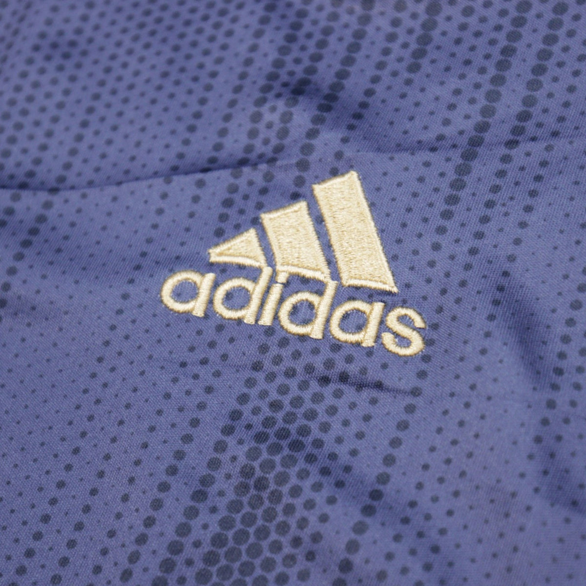 Close-up of the embroidered adidas logo on the shirt fabric