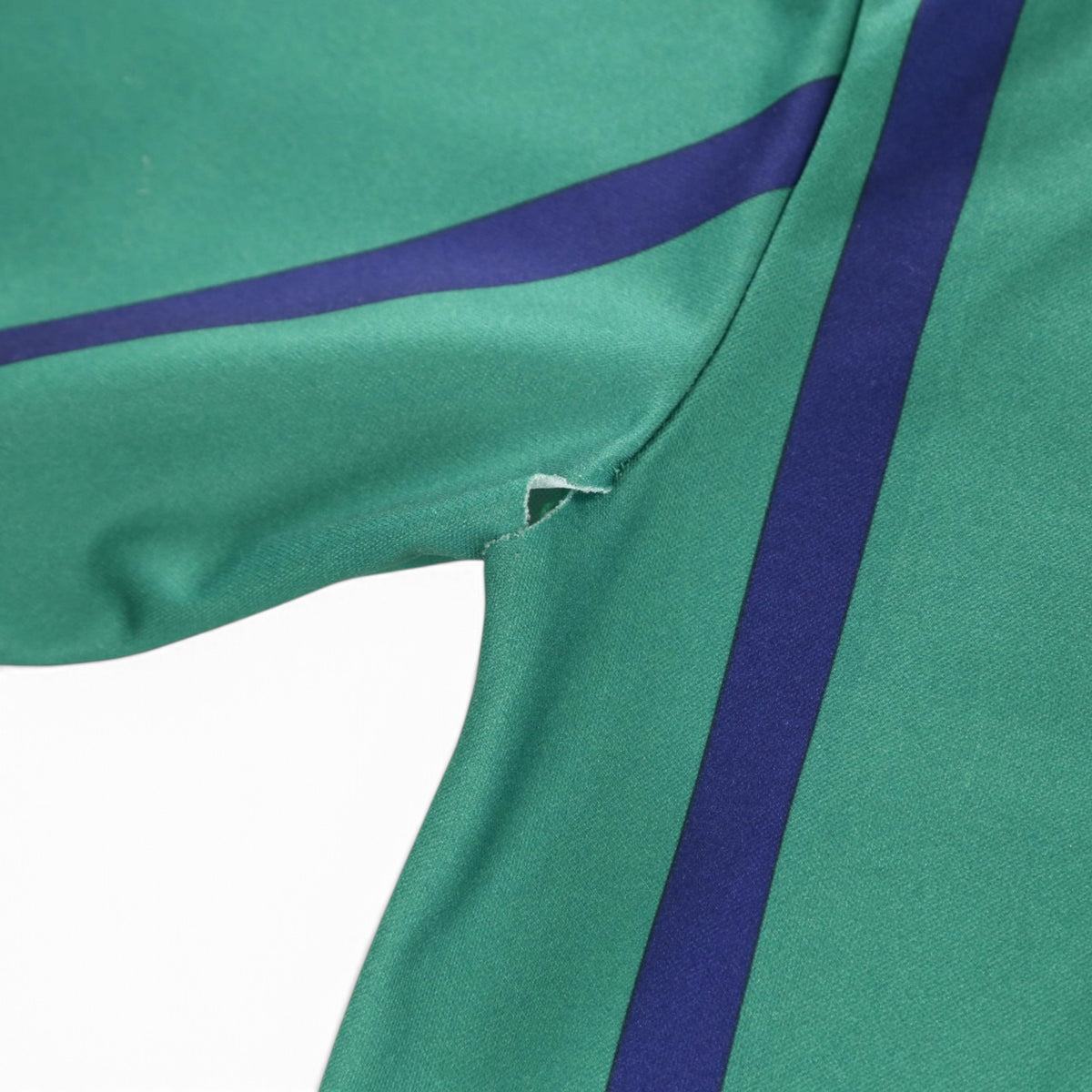 Close-up of small tear at the underarm seam on the shirt