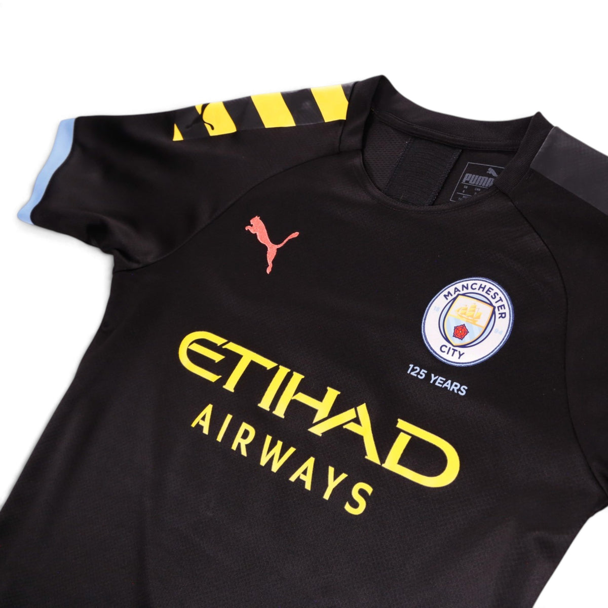 Close-up of the chest showing the Manchester City crest, Puma logo and neck label