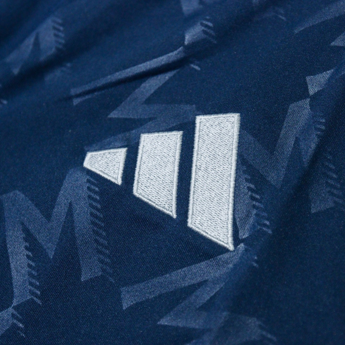 Close-up of adidas three-stripe logo on the chest