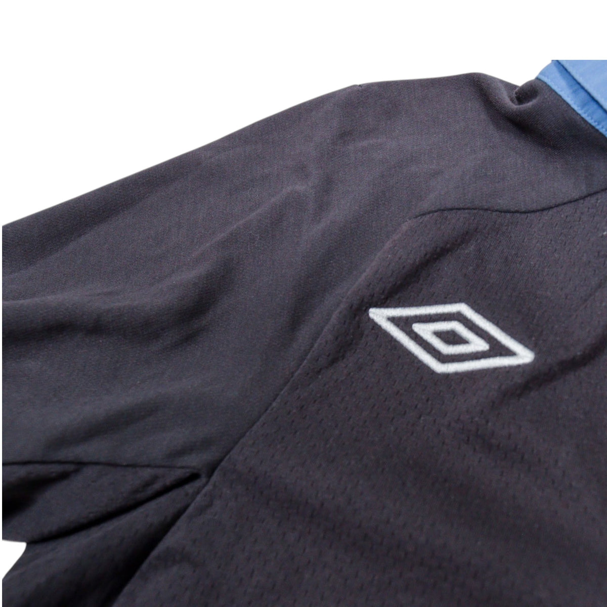 Close-up of the Umbro diamond logo on the sleeve showing fabric texture