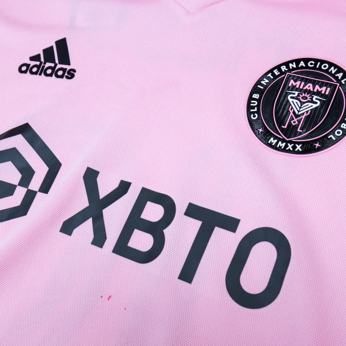Close-up of the adidas logo, crest and XBTO sponsor together on the chest