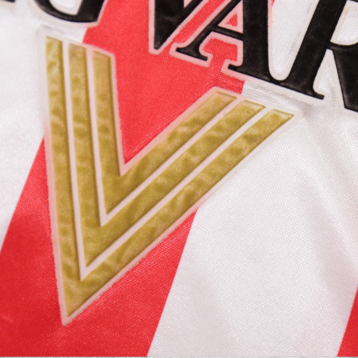 Close-up of the gold chevron beneath the Reg Vardy sponsor logo
