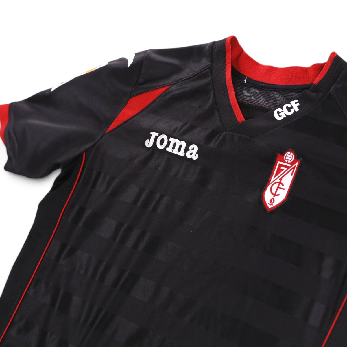 Close-up of collar, Joma logo and club crest on the chest