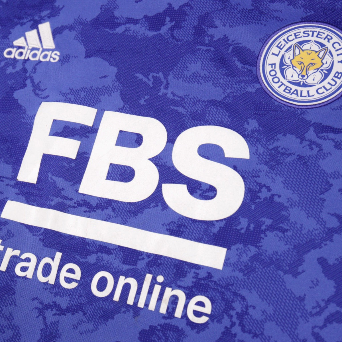 Close-up of Leicester City crest, adidas logo and FBS sponsor print on the home shirt
