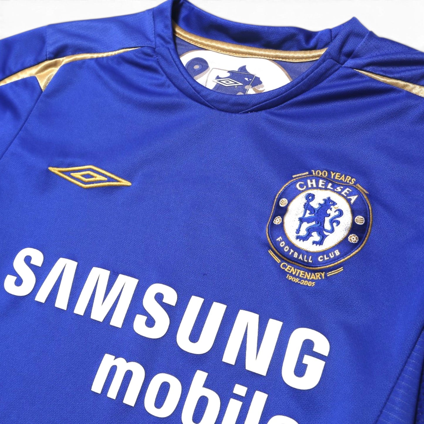 Close-up of Chelsea Centenary crest, Umbro logo, and Samsung Mobile sponsor on 2005-06 home shirt