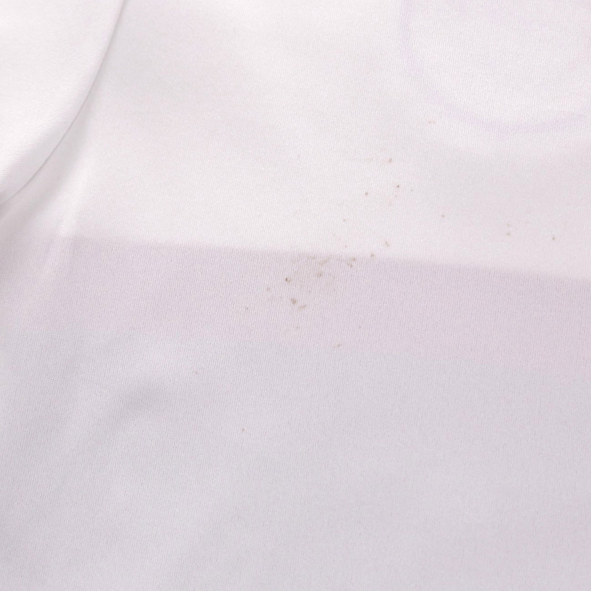 Close-up of small marks on the back of the white shirt fabric