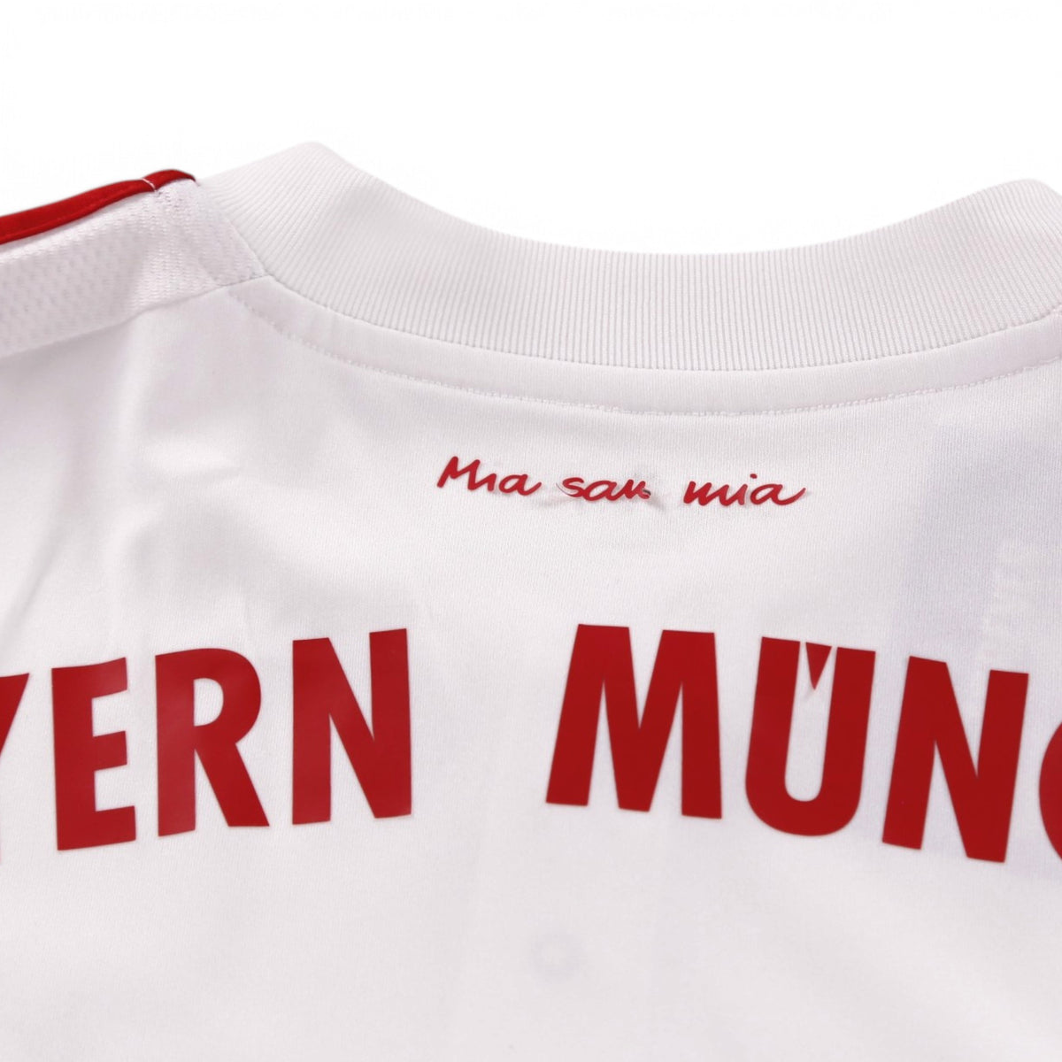 Close-up of neck label area with 'Mia san mia' print below the collar