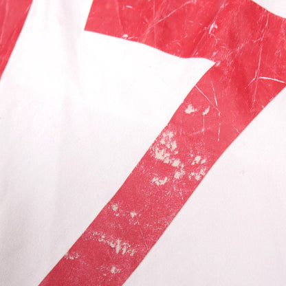 Close-up showing cracking and flaking of the red number print