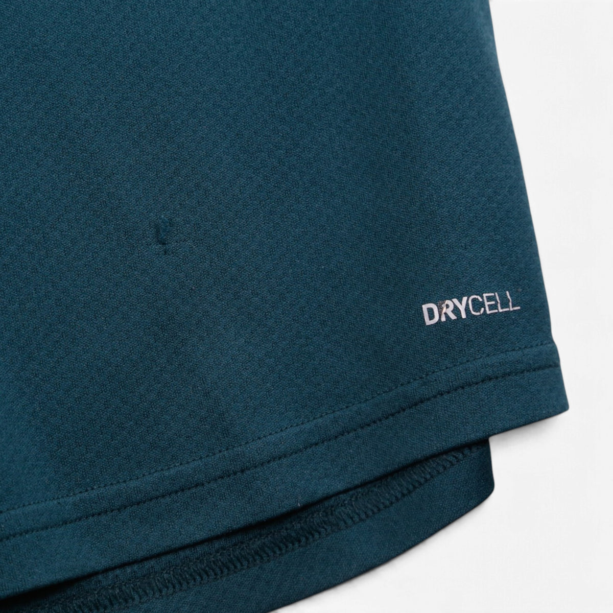 Close-up of hem showing DRYCELL branding and small mark on Newcastle United away shirt