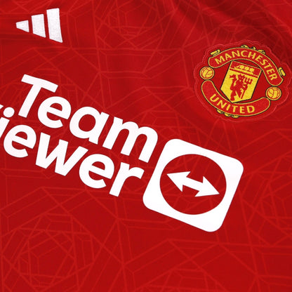 Close-up of adidas logo and Manchester United crest on chest