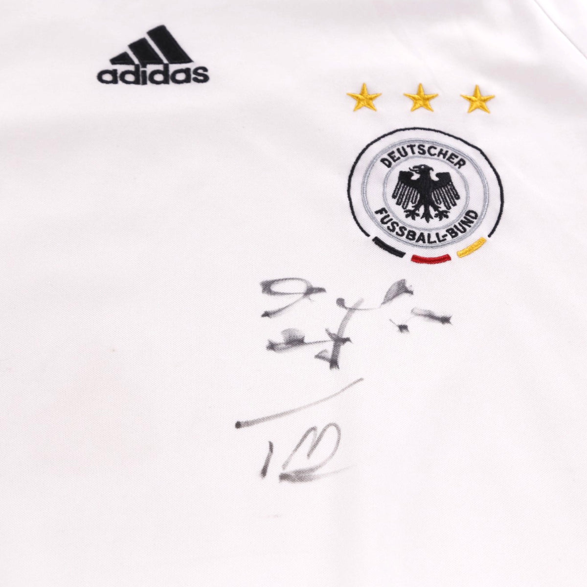 Close-up of adidas logo, Deutscher Fussball-Bund crest with three stars, and signature on the chest