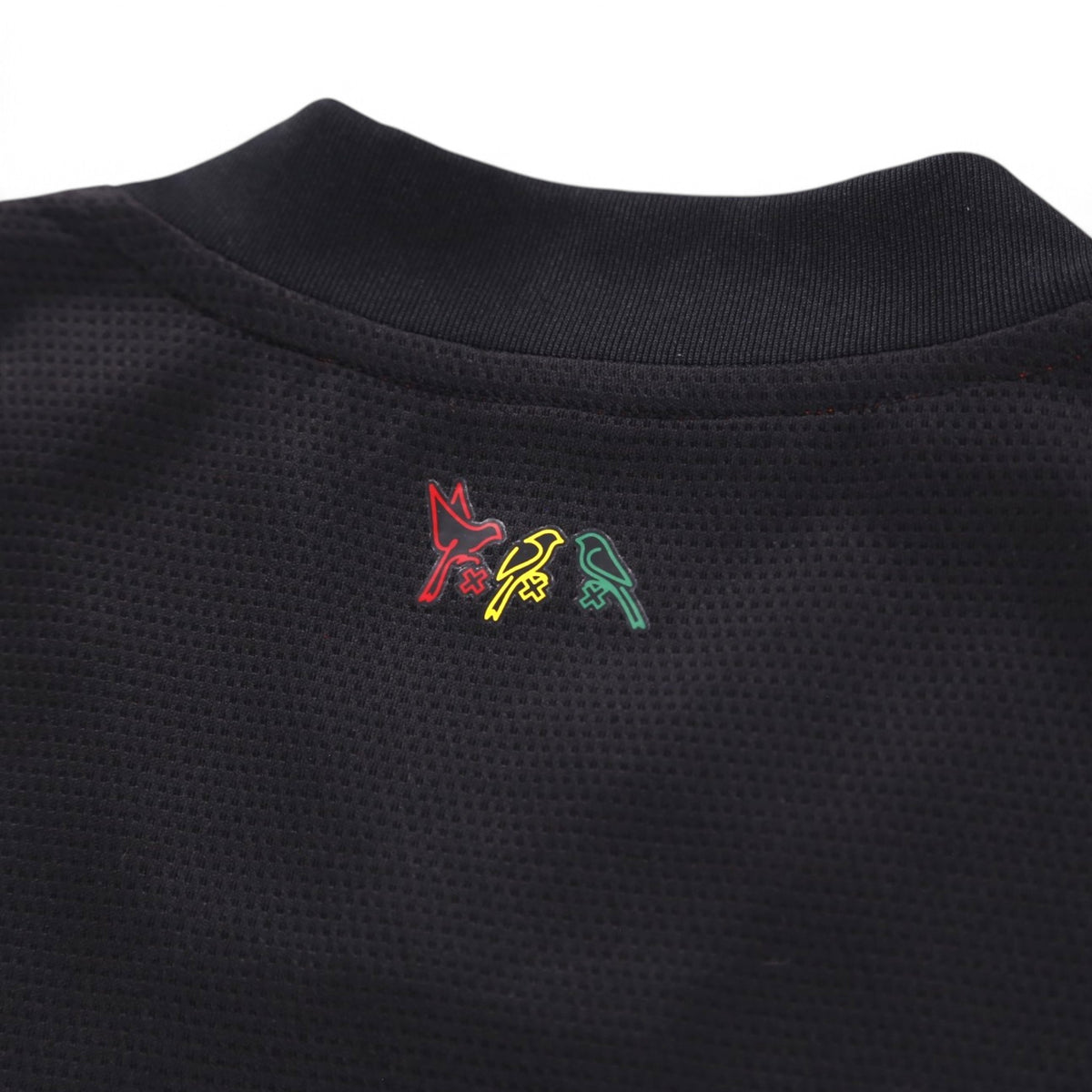 Close-up of small multicoloured bird motif below the back collar