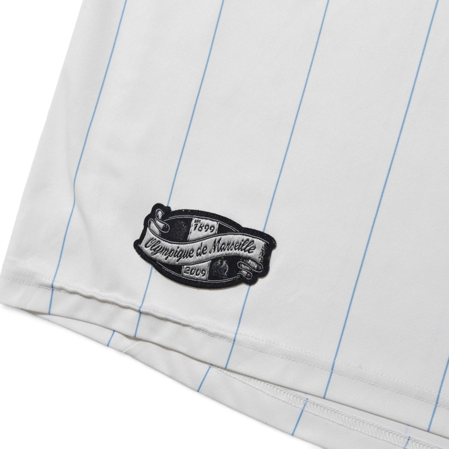Close-up of Olympique de Marseille anniversary patch on the hem