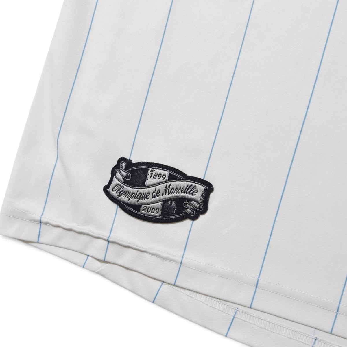 Close-up of Olympique de Marseille anniversary patch on the hem