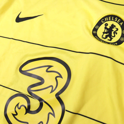Close-up of Chelsea crest, Nike swoosh and Three sponsor on the yellow 2021/22 away shirt