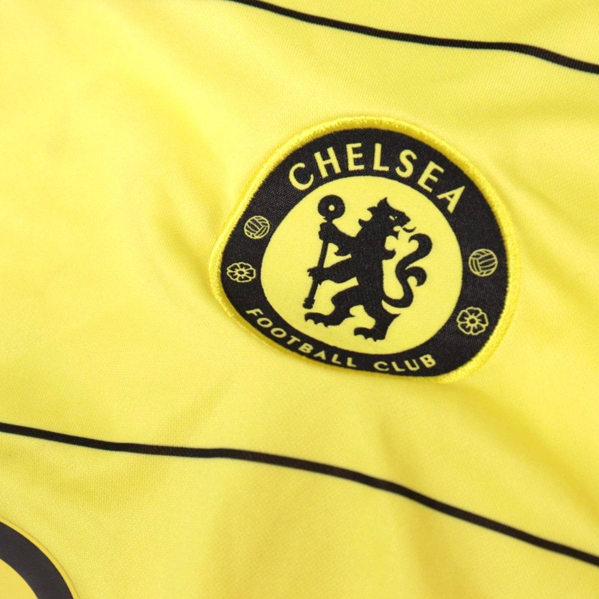 Detail of the embroidered Chelsea Football Club crest on the yellow away shirt