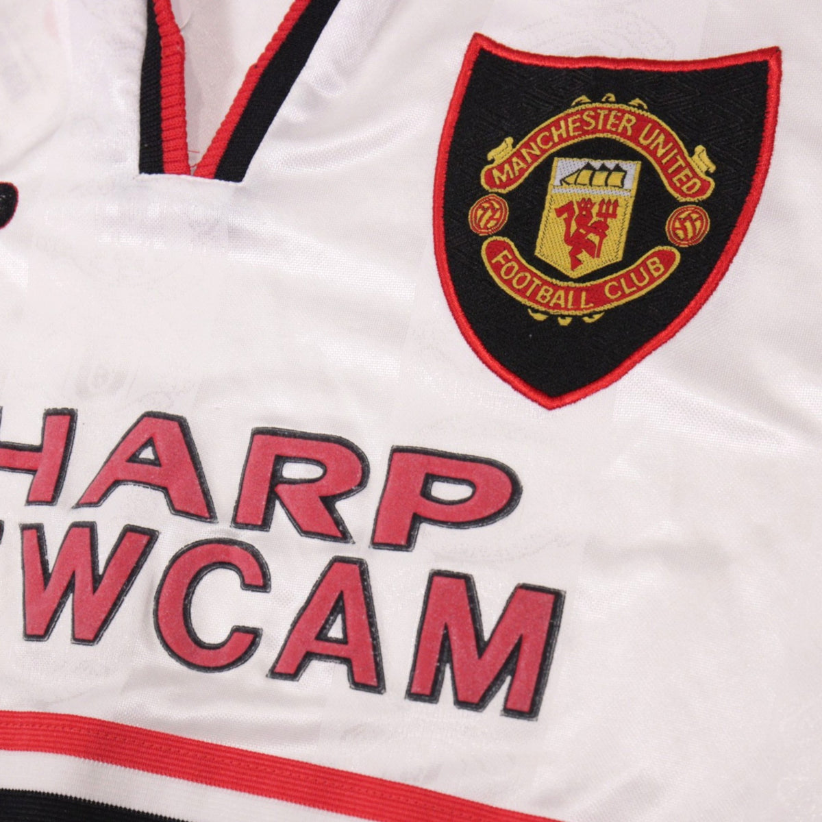 Close-up of Manchester United crest and Sharp Viewcam sponsor print
