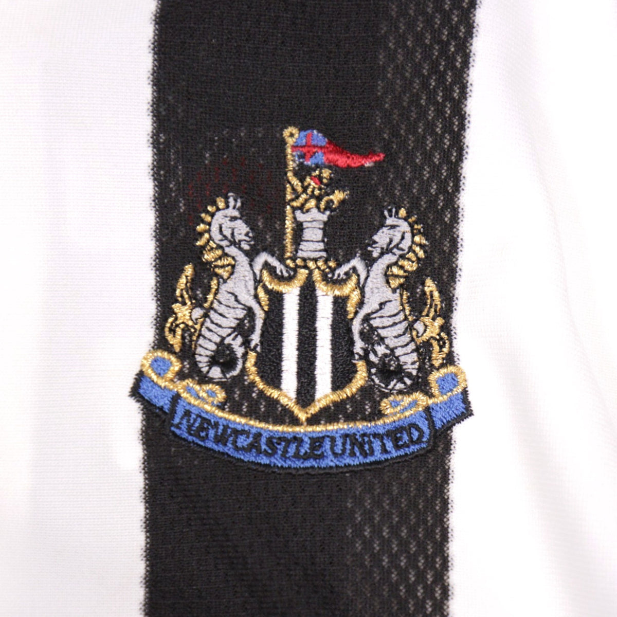 Close-up of the embroidered Newcastle United crest on the shirt