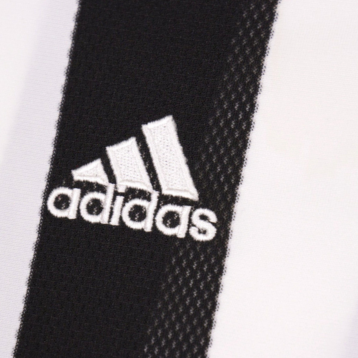 Close-up of the adidas logo embroidered on the chest stripe