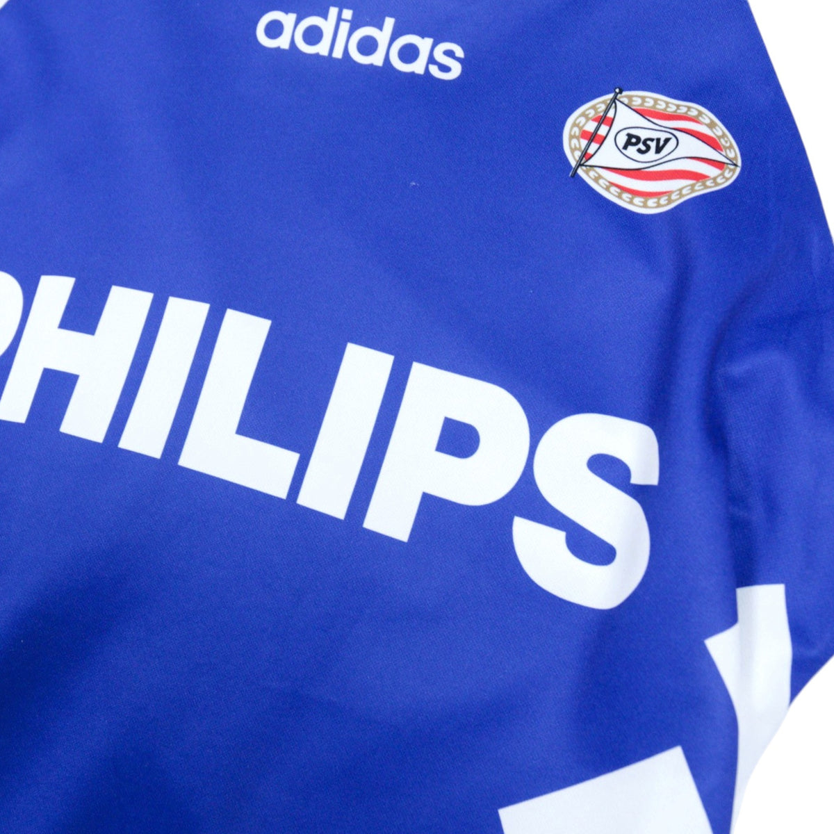 Close-up of the adidas logo, PSV crest and Philips sponsor on the chest