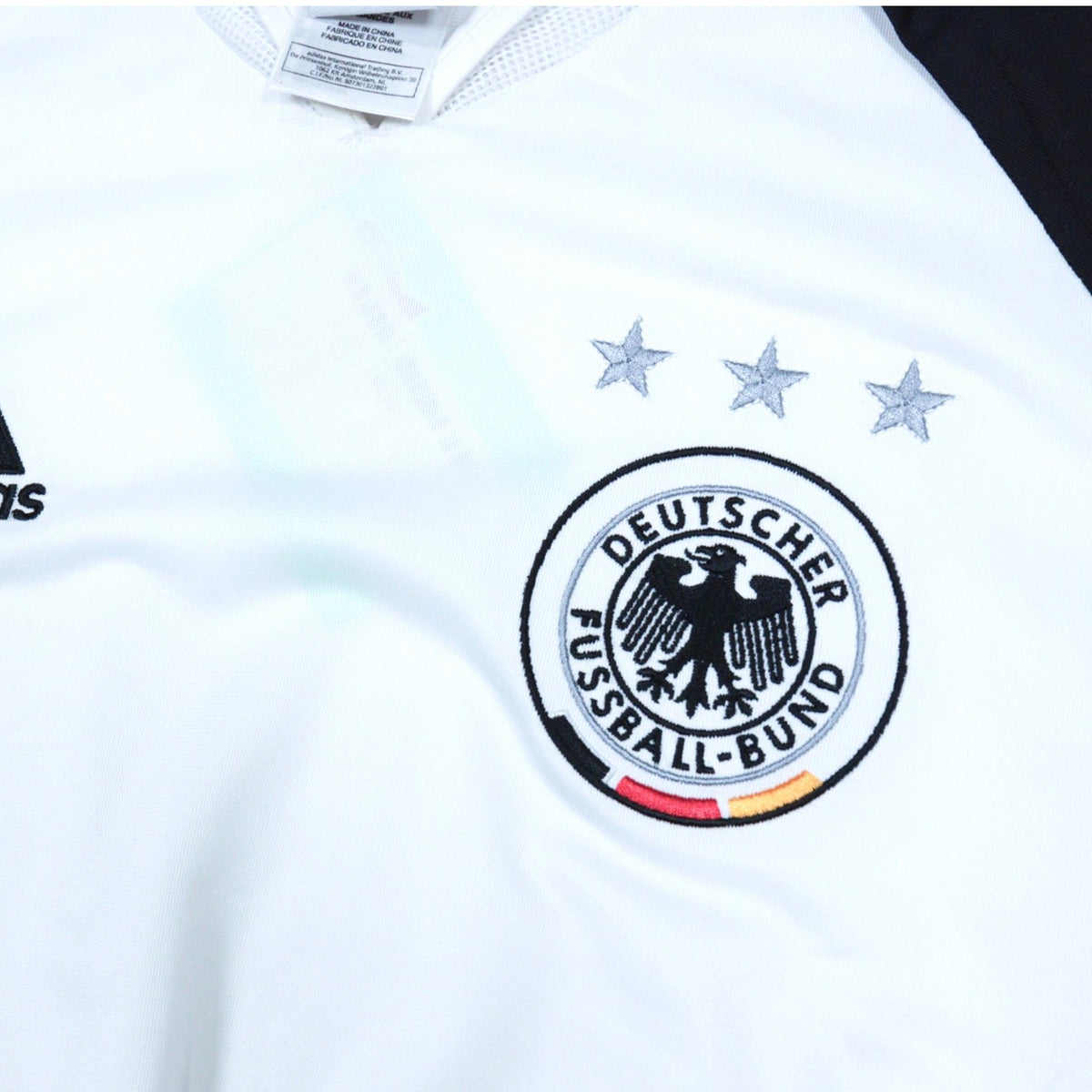 Close-up of the adidas logo and DFB crest on the chest with neck label visible