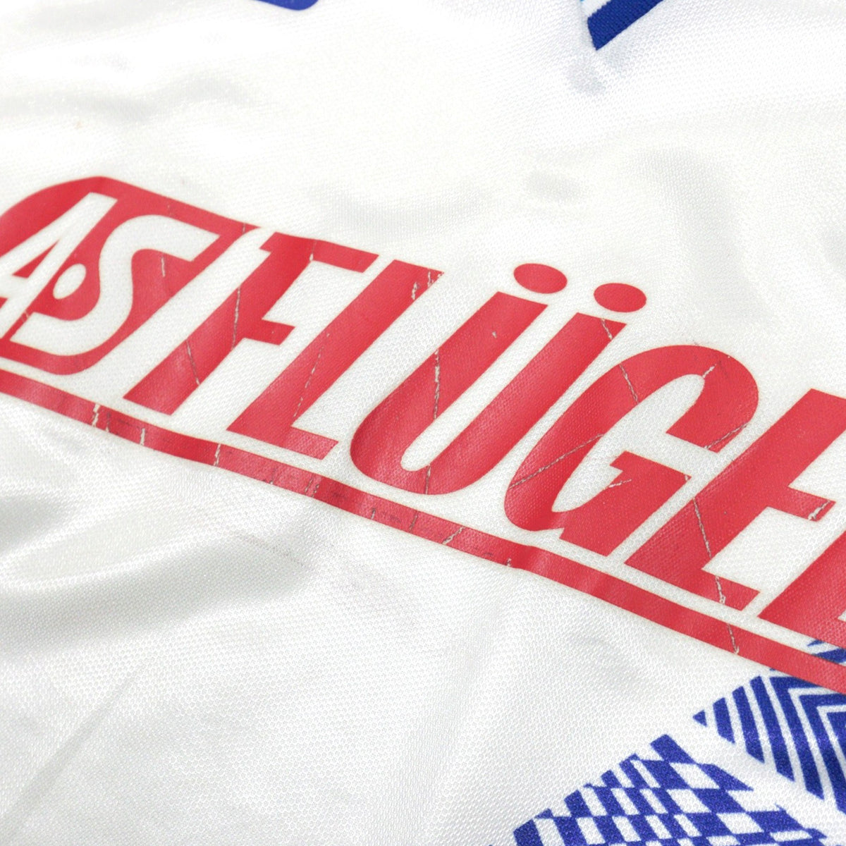 Close-up of the 'AS FLÜGELS' print on the chest of the shirt