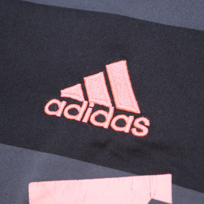 Close-up of adidas logo on chest with pink embroidery