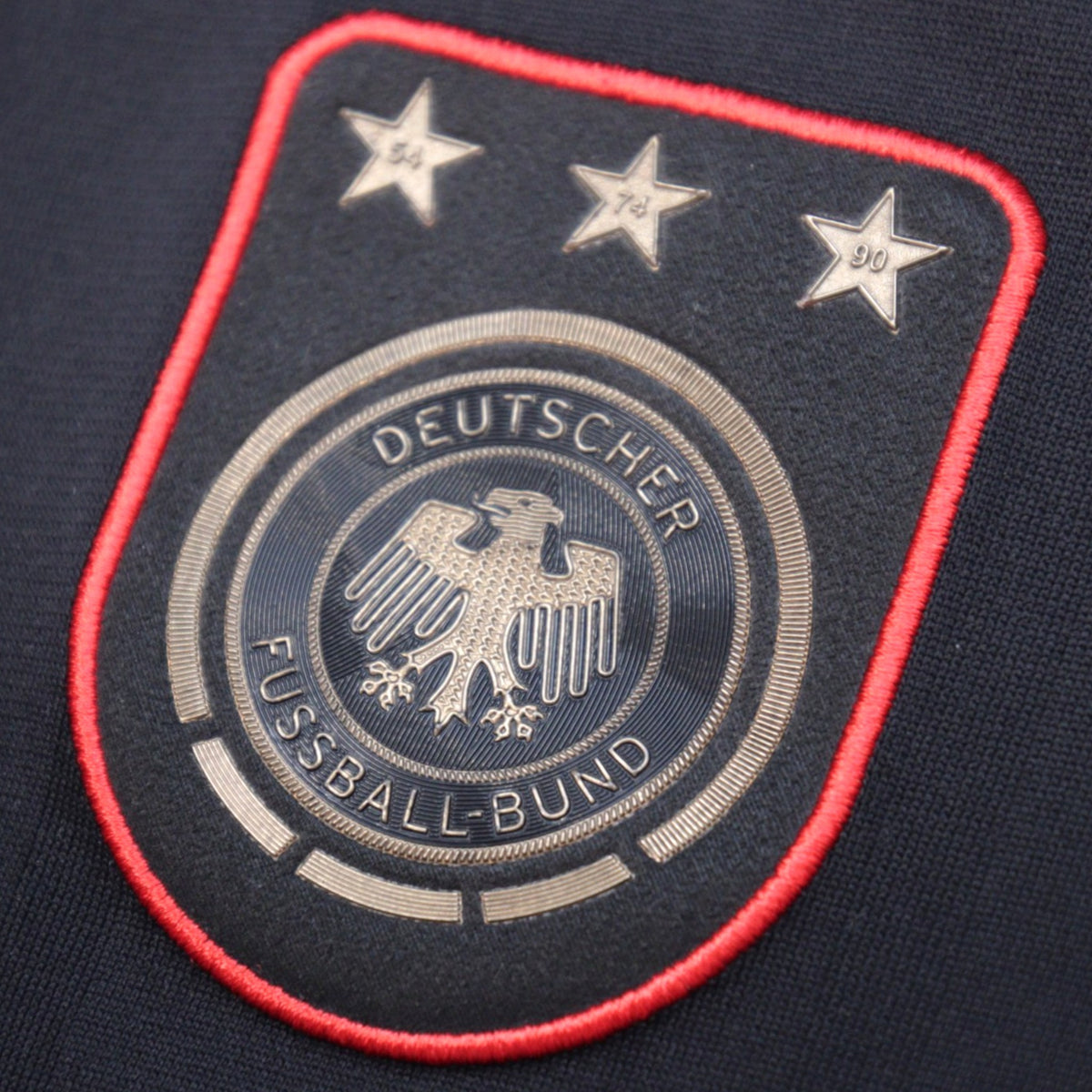 Close-up of the DFB crest with three World Cup stars on the 2010/11 Germany away shirt