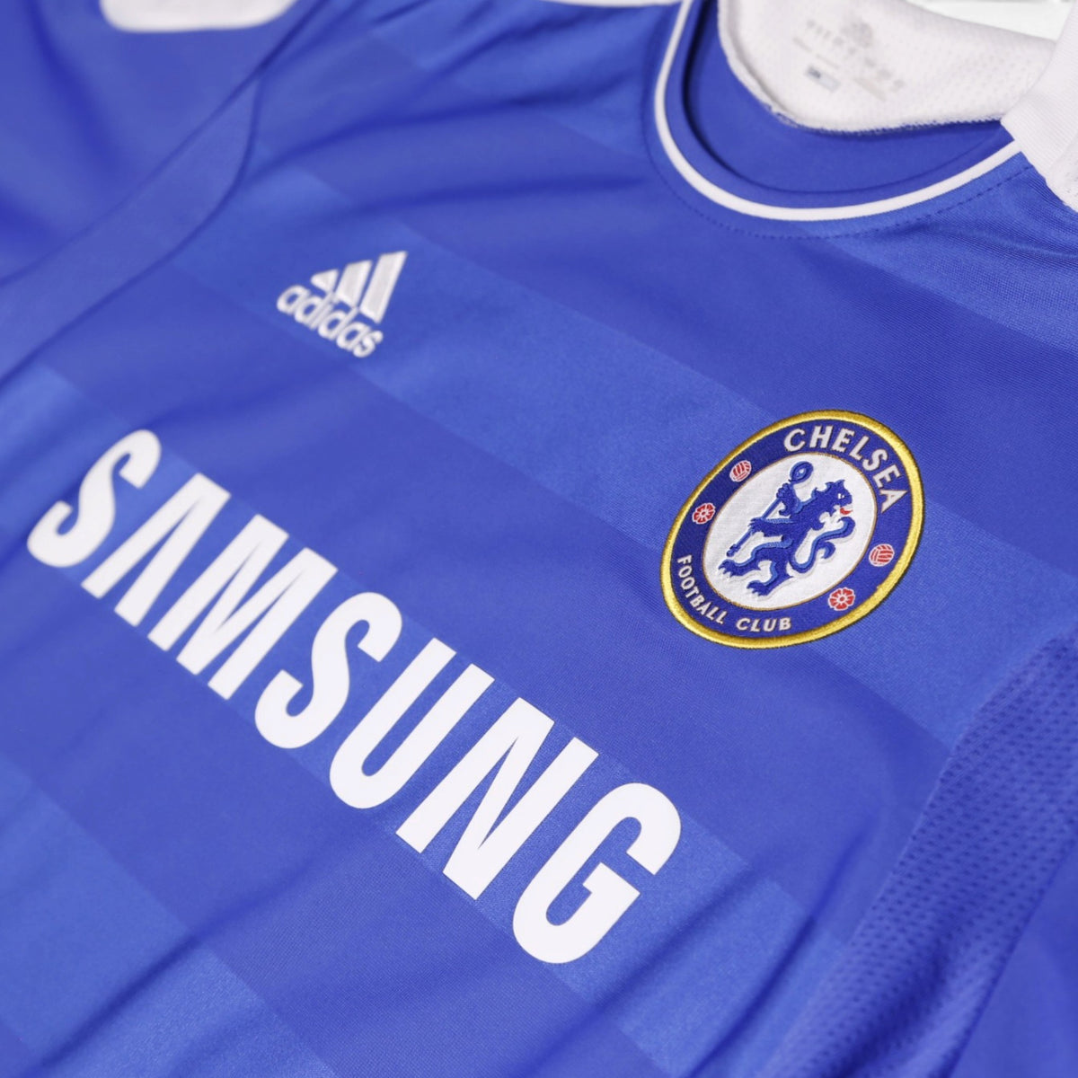 Close-up of adidas logo and Chelsea crest on the shirt front