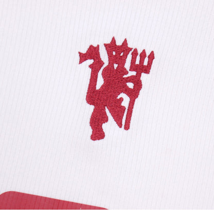 Close-up of embroidered Manchester United red devil crest on third shirt