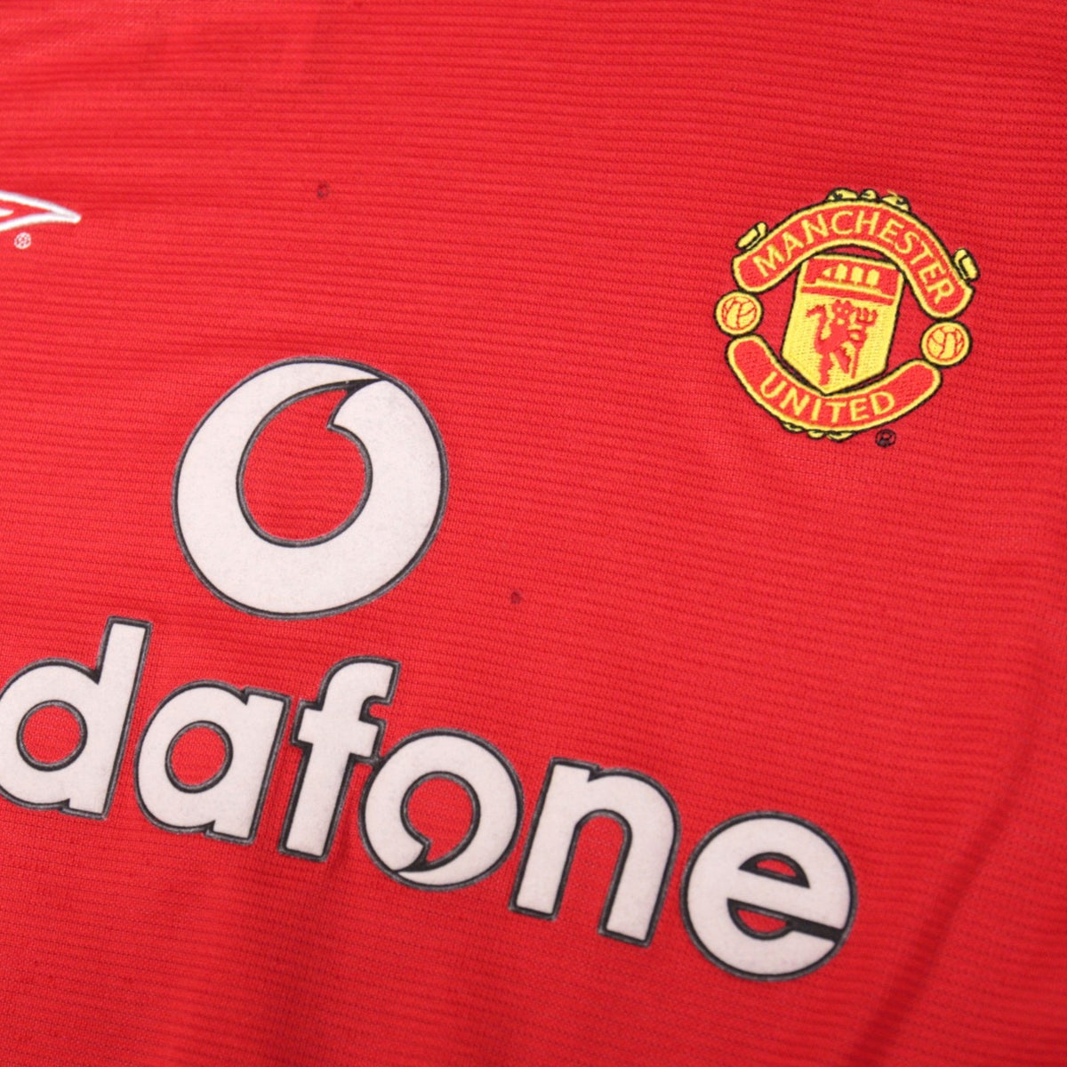 Close-up of the Manchester United crest and Vodafone sponsor print on the home shirt