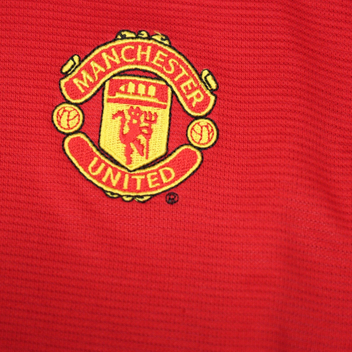 Close-up of the embroidered Manchester United crest on the shirt