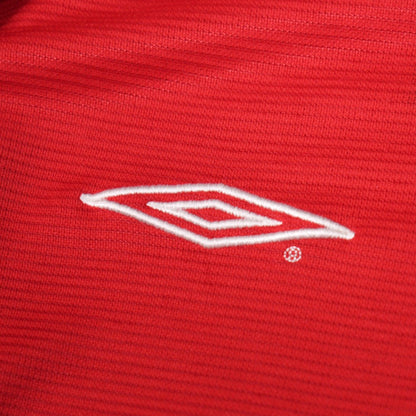 Close-up of the embroidered Umbro diamond logo on the shirt