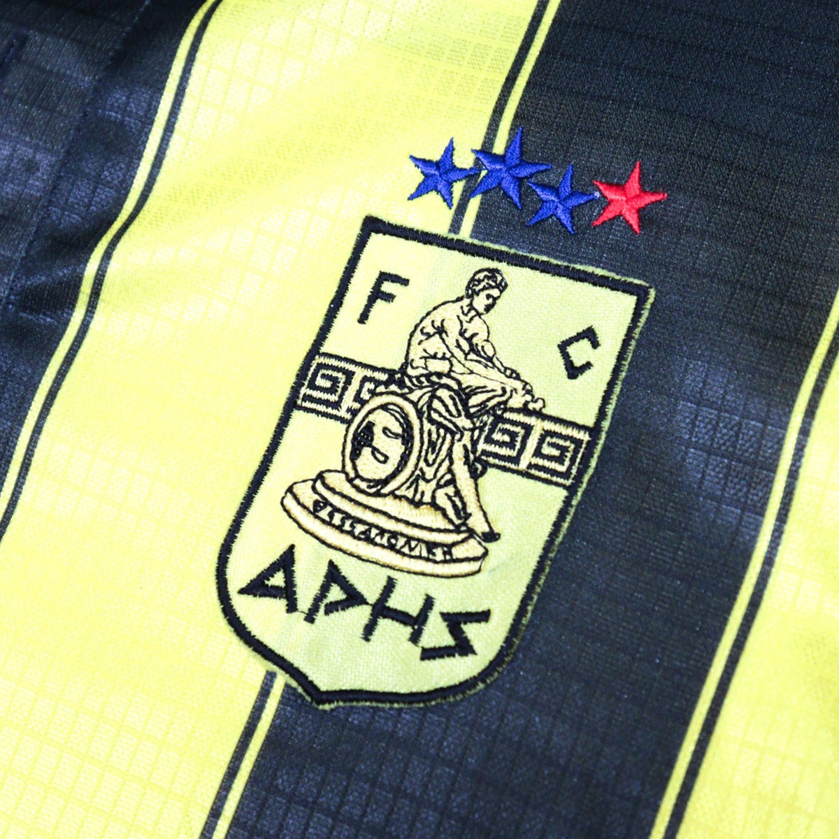 Close-up of Aris Thessaloniki crest with four stars above it