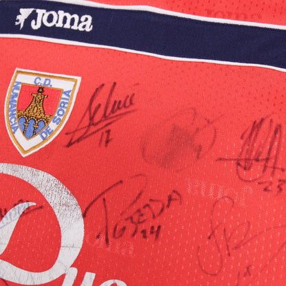 Close-up of Joma logo and signatures with faint mark near crest