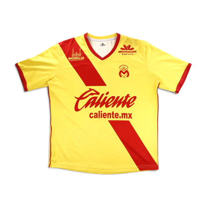 Monarcas Morelia 2017/18 home shirt front, yellow with red diagonal sash and Caliente sponsor