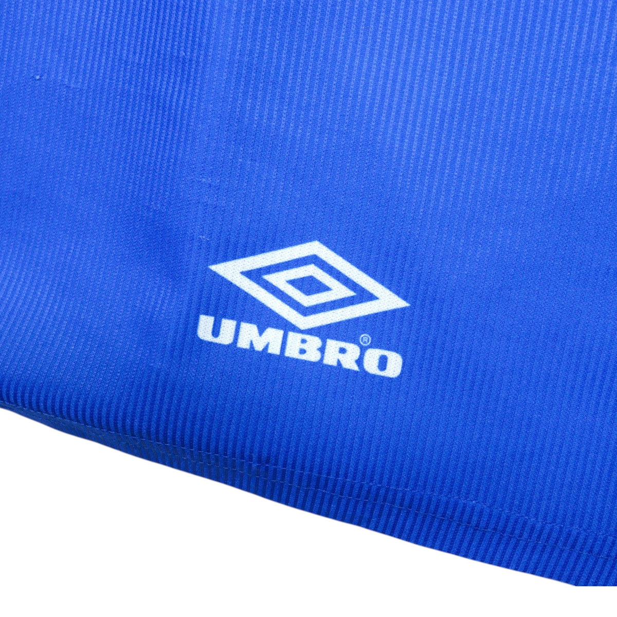 Close-up of the Umbro logo printed on the hem of the shirt