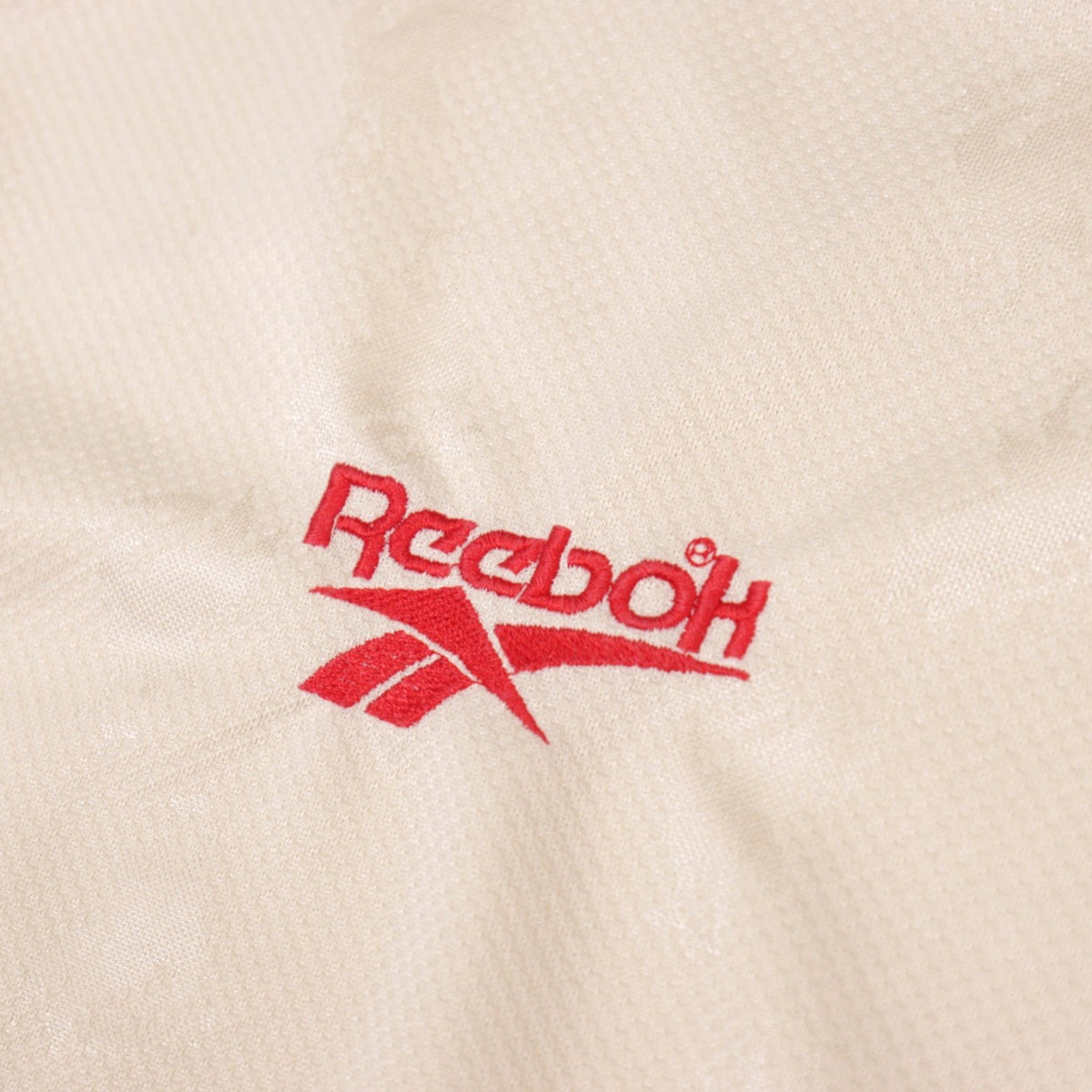 Close-up of the embroidered Reebok logo on the shirt fabric
