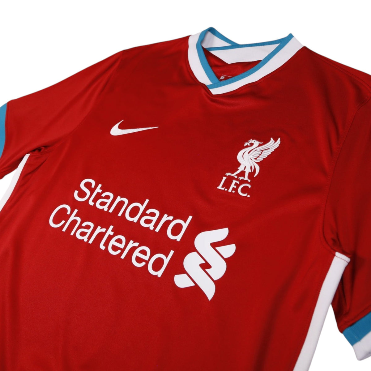 Close-up of Liverpool crest, Nike swoosh and Standard Chartered sponsor on the chest