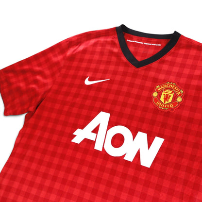 Close-up of the Manchester United crest, Nike swoosh and AON sponsor on the chest
