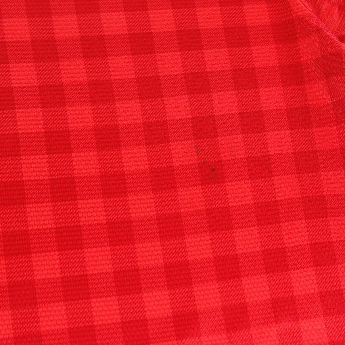 Close-up of the red check fabric showing a small mark