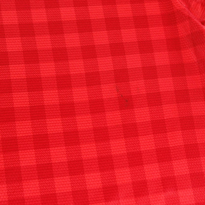 Close-up of the red check fabric showing a small mark
