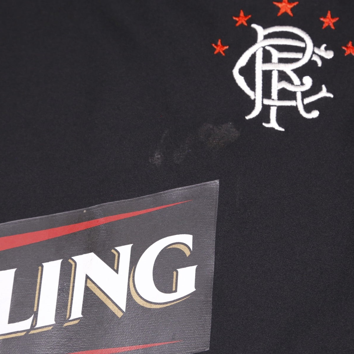Close-up of Rangers crest and Carling logo showing a faint mark