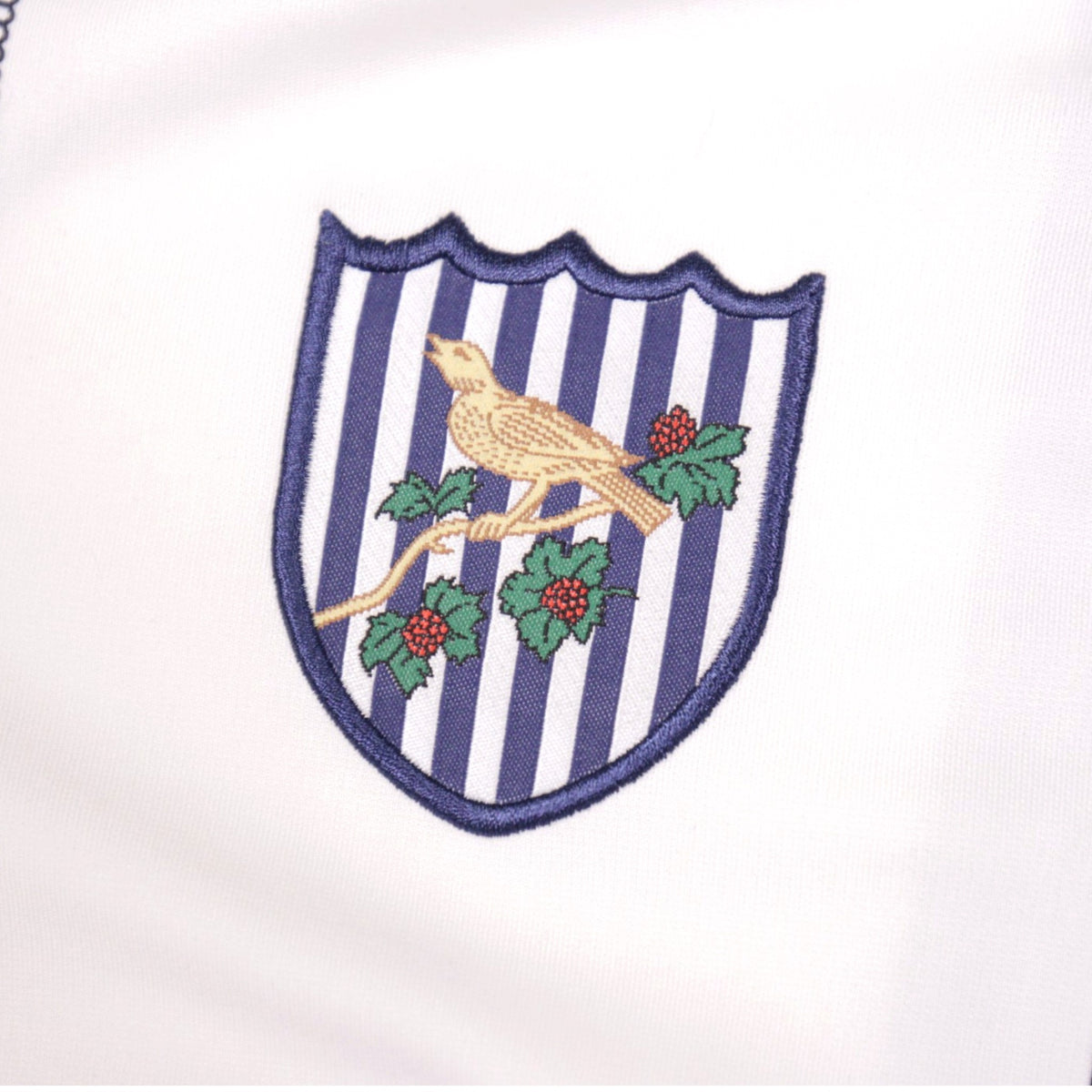 Close-up of the embroidered West Bromwich Albion throstle crest