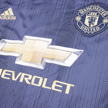 Close-up of adidas logo, Manchester United crest and Chevrolet sponsor on the chest