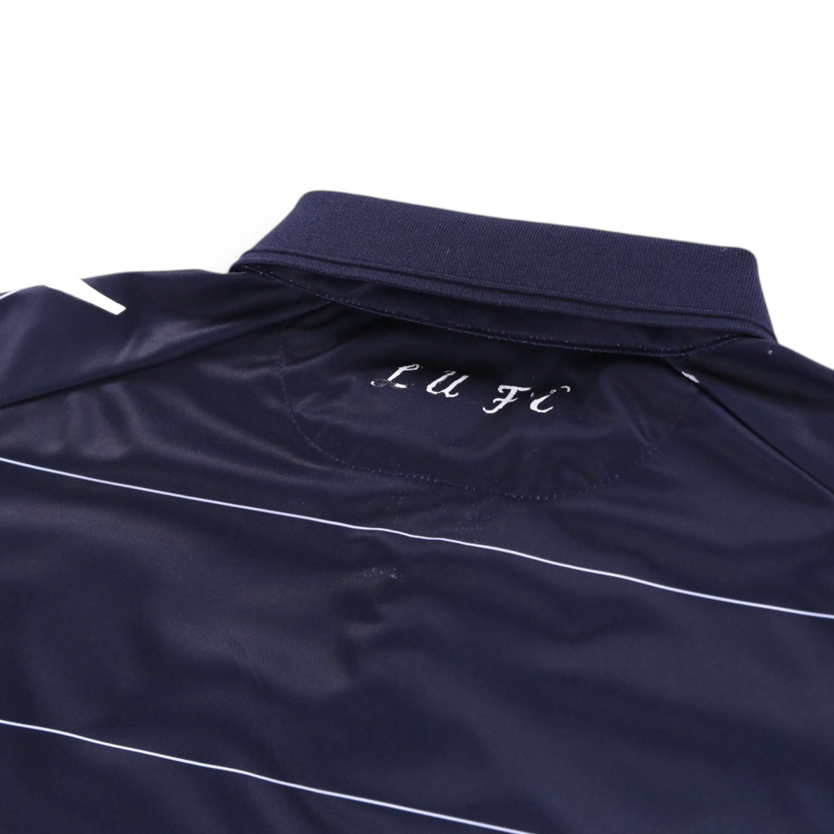 Close-up of Leeds United shirt collar with 'LUFC' script on the back neck