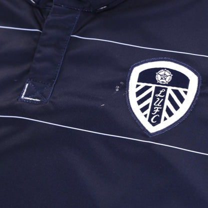 Close-up of the Leeds United crest and Macron logo on the chest with a small mark visible