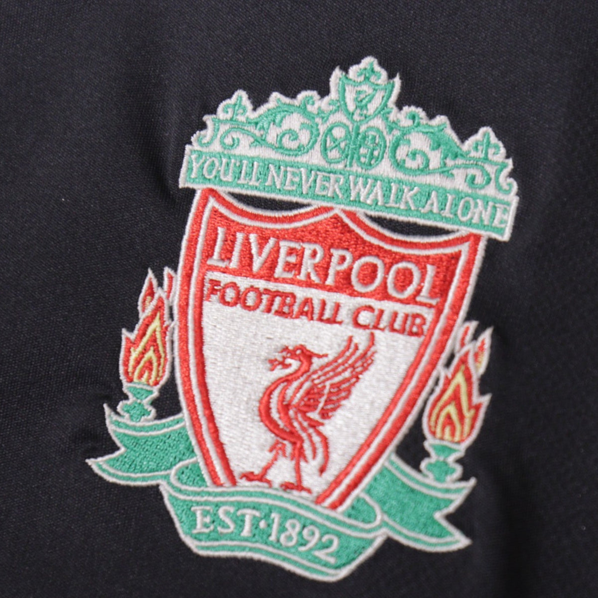 Close-up of Liverpool crest detail showing 'You'll Never Walk Alone' and liver bird